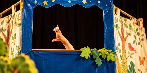 Spectacle de contes pour la petite enfance avec une marionnette à main dans un petit théâtre.